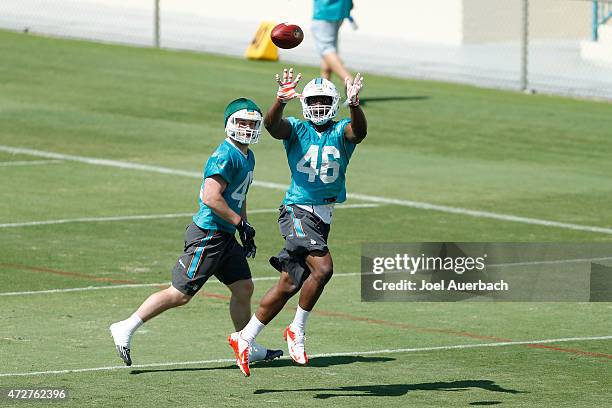 Neville Hewitt catches the ball in front of Mike Hull of the Miami Dolphins during the rookie minicamp on May 9, 2015 at the Miami Dolphins training...