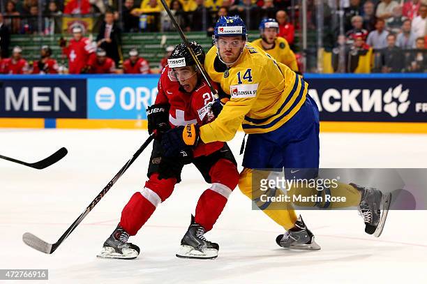 Mattias Ekholm of Sweden and Reto Suri of Switzerland battle for the puck during the IIHF World Championship group A match between Austria and...