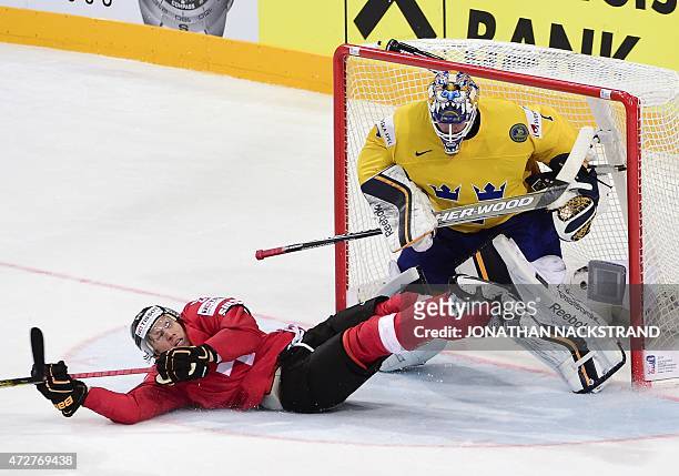 Forward Damien Brunner of Switzerland falls next to goalkeeper Jhonas Enroth of Sweden during the group A preliminary round match Sweden vs...