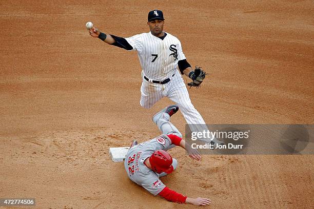 Micah Johnson of the Chicago White Sox leaps in the air to throw to first base as Jay Bruce of the Cincinnati Reds slides into second base during the...