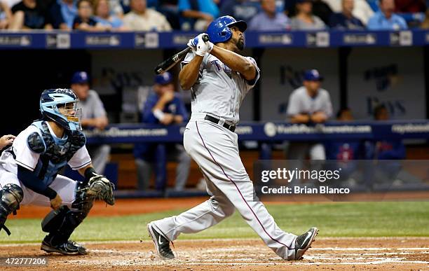 Carlos Peguero of the Texas Rangers hits a two-run home run in front of catcher Rene Rivera of the Tampa Bay Rays during the fourth inning of a game...