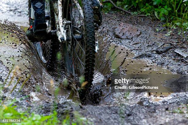 bicicleta de montaña en un charco de lodo - bike rain fotografías e imágenes de stock