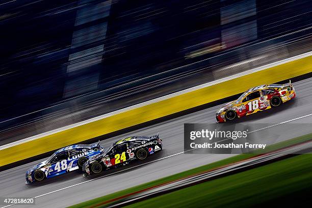 Jimmie Johnson, driver of the Lowe's Chevrolet, leads Jeff Gordon, driver of the American Red Cross Chevrolet, and Erik Jones, driver of the M&M's...