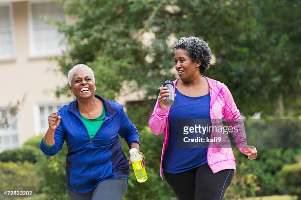 two senior black women exercising together - walking stock pictures, royalty-free photos & images