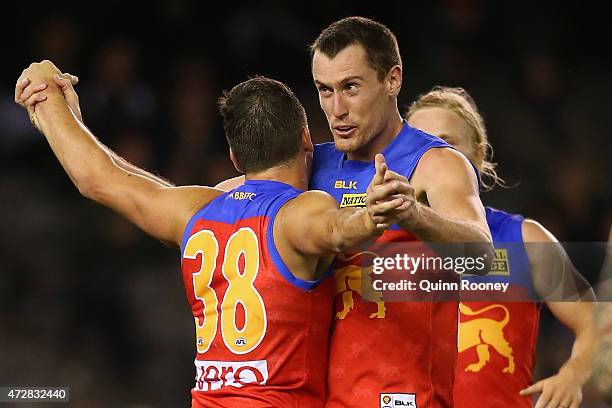 Tom Rockliff of the Lions is congratulated by Matthew Leuenberger after kicking a goal during the round six AFL match between the Carlton Blues and...