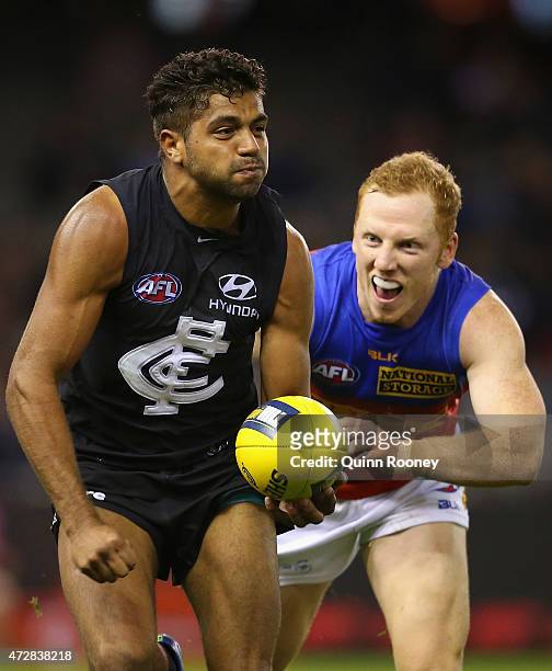 Clem Smith of the Blues handballs whilst being tackled by Josh Green of the Lions during the round six AFL match between the Carlton Blues and the...