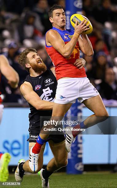 Tom Rockliff of the Lions marks infront of Zach Tuohy of the Blues during the round six AFL match between the Carlton Blues and the Brisbane Lions at...