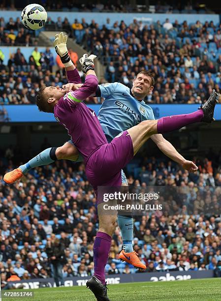 Queens Park Rangers' English goalkeeper Robert Green clashes with Manchester City's English midfielder James Milner during the English Premier League...