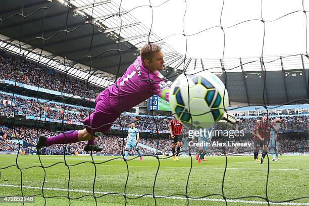 Goalkeeper Robert Green of QPR dives in vain as Aleksandar Kolarov of Manchester City scores his team's second goal from a kick during the Barclays...