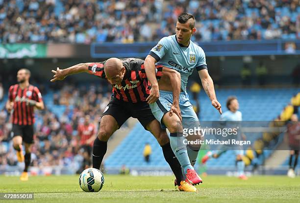 Karl Henry of QPR is challenged by Sergio Aguero of Manchester City during the Barclays Premier League match between Manchester City and Queens Park...
