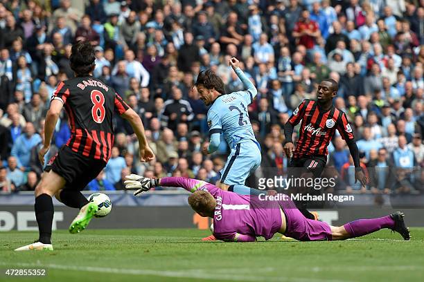David Silva of Manchester City scres his team's sixth goal past the outstretched Robert Green of QPR during the Barclays Premier League match between...