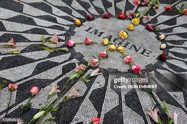 The rose covered mosaic of inlaid stones with the title of John Lennon's famous song "Imagine" is seen in Central Park's Strawberry Fields 07...