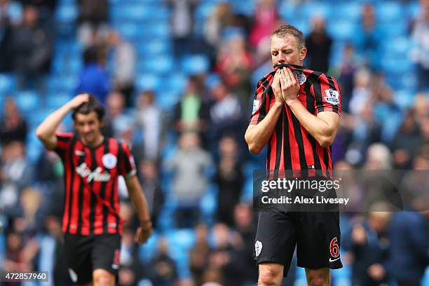 Dejected Clint Hill and Joey Barton of QPR react following their team's relegation during the Barclays Premier League match between Manchester City...