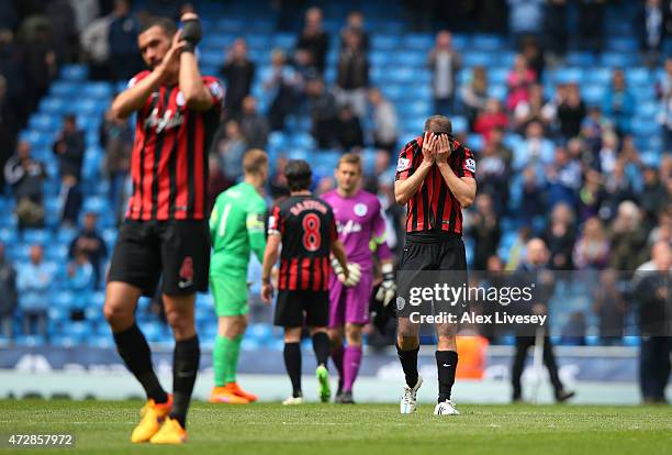 Dejected Clint Hill of QPR and teammates react following their team's relegation during the Barclays Premier League match between Manchester City and...