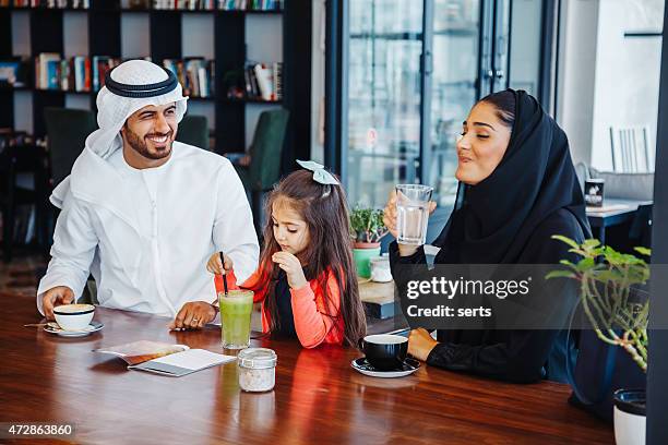 traditional young arab family enjoying at cafe - arabian peninsula stock pictures, royalty-free photos & images