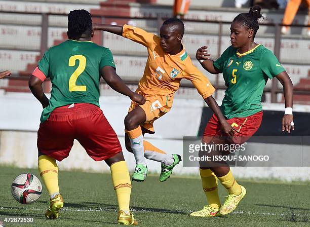 Ivory Coast's Ange Koko Nguessan vies with Cameroon's Etangue Siliki and Cameroon's Christine Mani during a women friendly football match between...