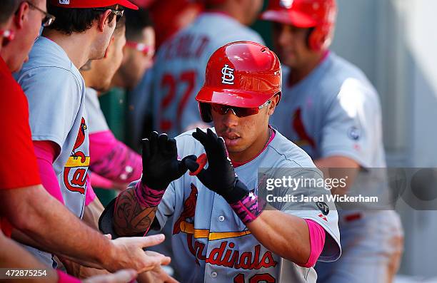 Kolten Wong of the St Louis Cardinals is congratulated by his teammates in the dugout after hitting a two-run home run in the sixth inning against...