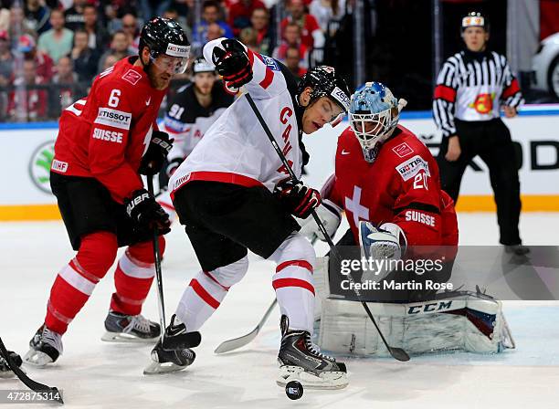 Timo Helbling of Switzerland and Taylor Hall of Canada battle for the puck during the IIHF World Championship group A match between Switzerland and...