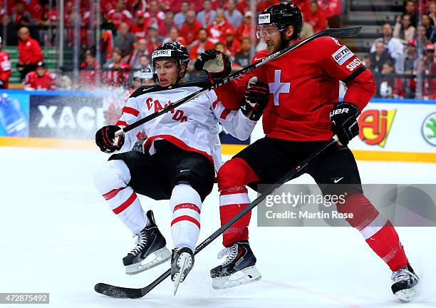 Timo Helbling of Switzerland and Taylor Hall of Canada battle for the puck during the IIHF World Championship group A match between Switzerland and...