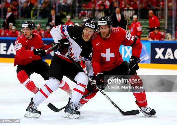 Timo Helbling of Switzerland and Taylor Hall of Canada battle for the puck during the IIHF World Championship group A match between Switzerland and...