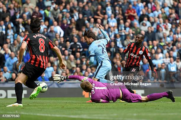 David Silva of Manchester City scres his team's sixth goal past the outstretched Robert Green of QPR during the Barclays Premier League match between...