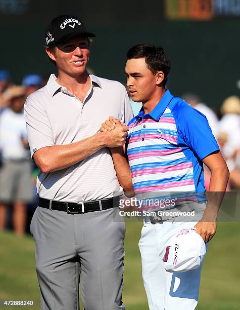 Derek Fathauer congratulates Rickie Fowler after Fowler finished at 12 under par during the final round of THE PLAYERS Championship at the TPC...
