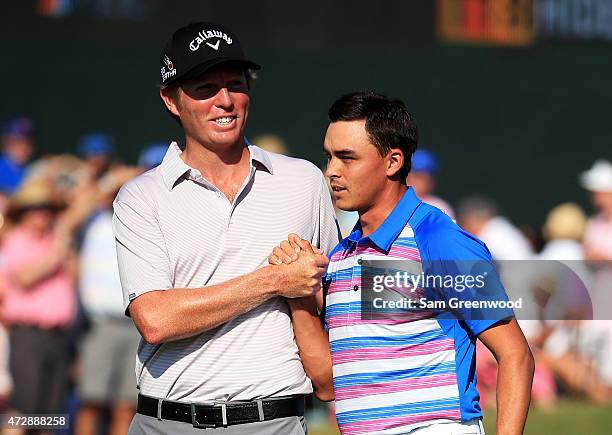 Derek Fathauer congratulates Rickie Fowler after Fowler finished at 12 under par during the final round of THE PLAYERS Championship at the TPC...