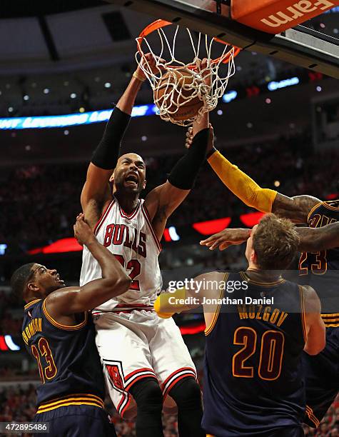 Taj Gibson of the Chicago Bulls dunks over Tristan Thompson and Timofey Mozgov of the Cleveland Cavaliers in Game Four of the Eastern Conference...