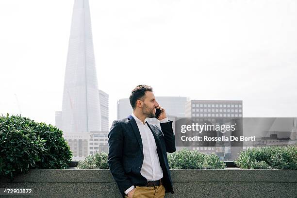 businessman talking on the phone, the shard on background - bringing home the bacon engelse uitdrukking stockfoto's en -beelden