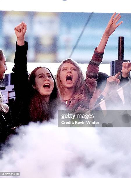 Musicians Alana Haim of HAIM and Taylor Swift watch from backstage as DJ Calvin Harris performs during 102.7 KIIS FM's Wango Tango at StubHub Center...