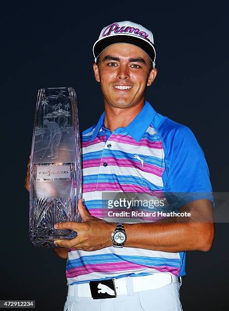 Rickie Fowler celebrates with the winner's trophy after the final round of THE PLAYERS Championship at the TPC Sawgrass Stadium course on May 10,...