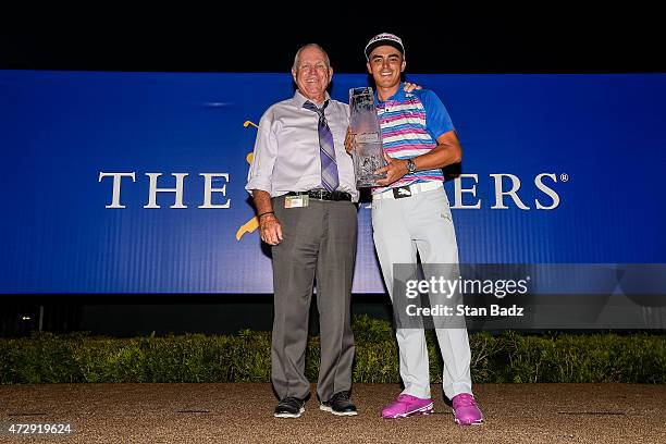 Rickie Fowler holds the championship trophy with his swing coach Butch Harmon after winning in a sudden death playoff during the final round of THE...