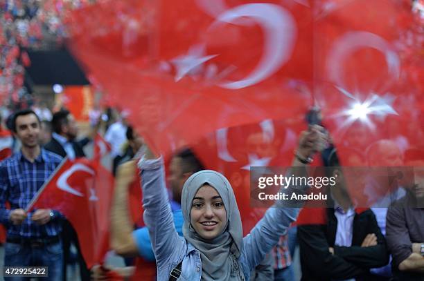 People wave Turkish flags as Turkeys President Recep Tayyip Erdogan gives a speech during an event organized by Turkish youth organizations at Ethias...