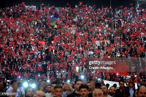 People wave Turkish flags as Turkeys President Recep Tayyip Erdogan gives a speech during an event organized by Turkish youth organizations at Ethias...