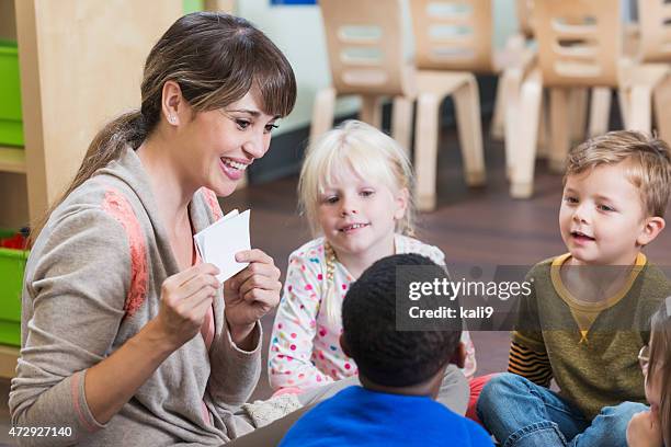 teacher in preschool classroom with group of children - teacher holding flash cards stock pictures, royalty-free photos & images