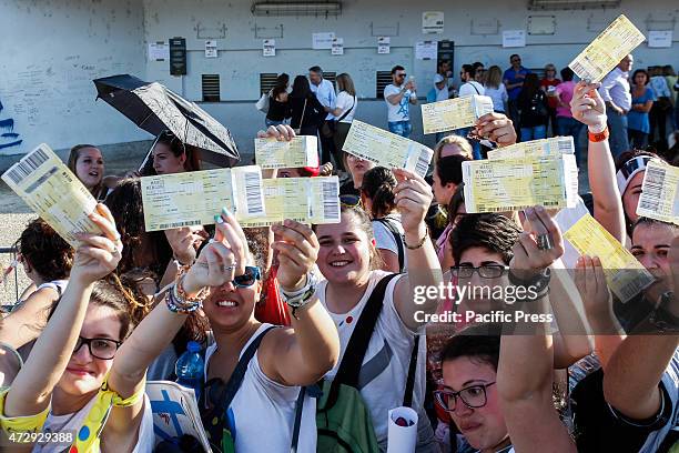 Hundreds of fans, under a hot sun, show tickets for the concert of Italian singer Marco Mengoni.