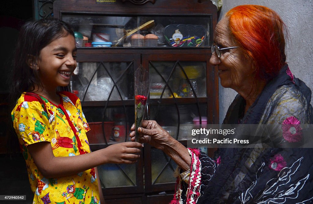 A young girl presenting a gift of flower to her grandmother...