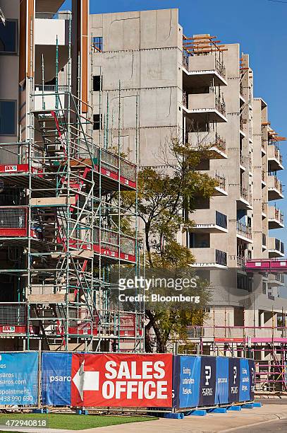 Sign pointing to a sales office is displayed in front of an apartment block under construction in Perth, Australia, on Sunday, May 10, 2015. Prime...