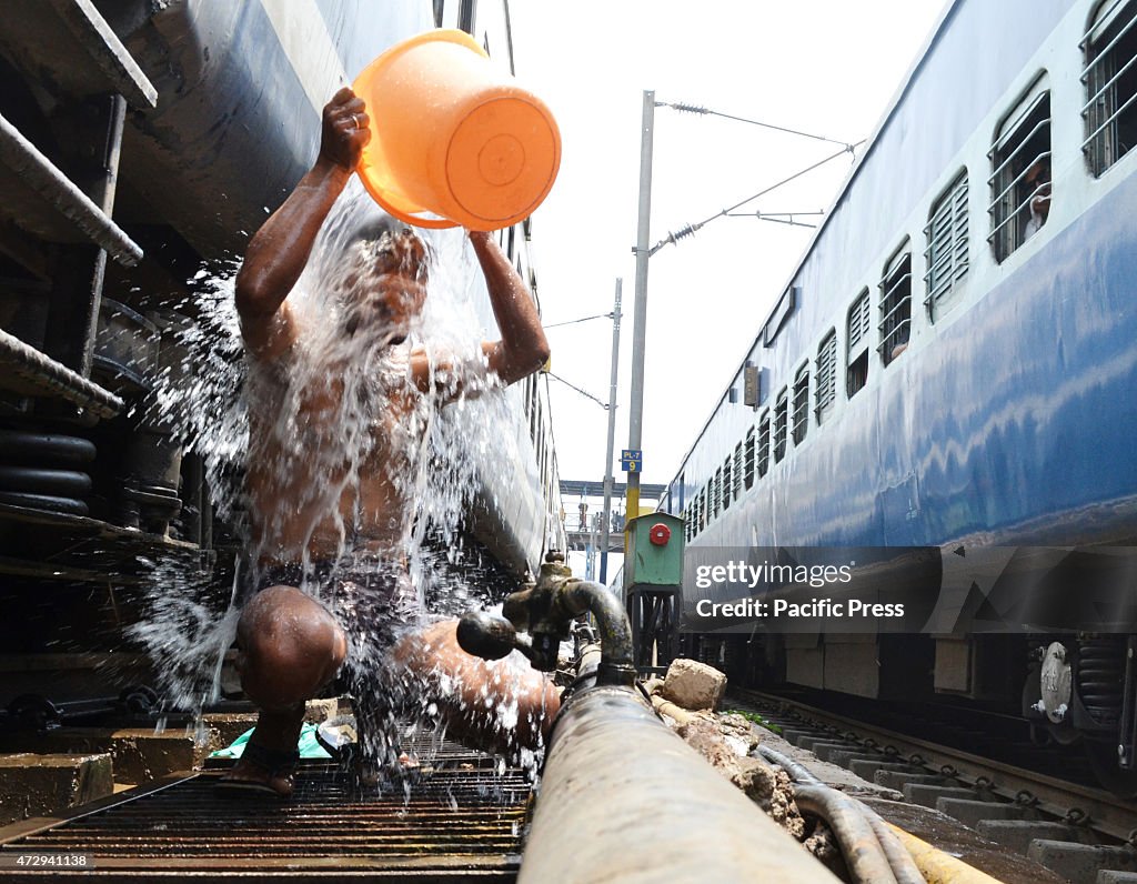 A man taking a bath in between the train railways during the...