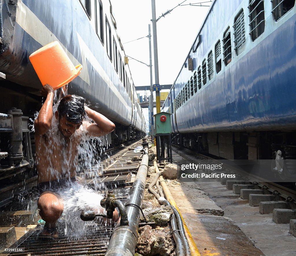 A man taking a bath in between the train railways during the...