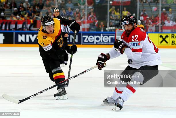 Justin Krueger of Germany and Nicolas Petrik of Austria battle for the puck during the IIHF World Championship group A match between Germany and...