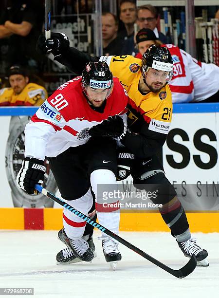 Nicolas Krammer of Germany and Alexander Pallestrang of Austria battle for the puck during the IIHF World Championship group A match between Germany...