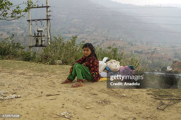 Girl sits next to the food supplies as she wait for her mother at Charuwa village some 52 Kilometer east from Kathmandu, on May 11, 2015. The number...