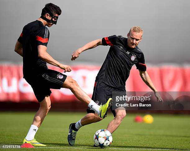 Robert Lewandowski is challenged by Sebastian Rode during a Bayern Muenchen training session on the eve of the UEFA Champions League semi final...