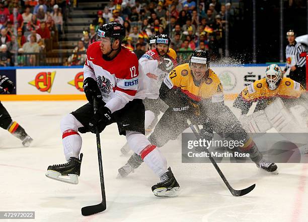 Christoph Ullmann of Germany and Michael Raffl of Austria battle for the puck during the IIHF World Championship group A match between Germany and...