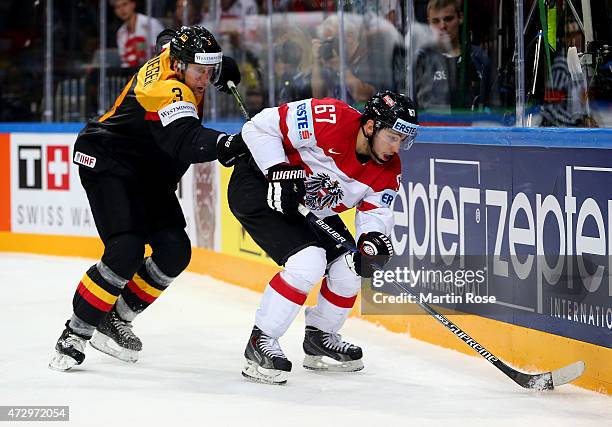 Justin Krueger of Germany and Konstantin Komarek of Austria battle for the puck during the IIHF World Championship group A match between Germany and...