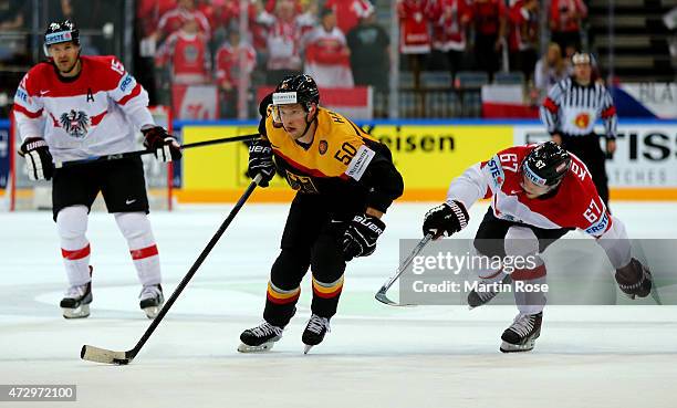 Patrick Hager of Germany and Konstantin Komarek of Austria battle for the puck during the IIHF World Championship group A match between Germany and...