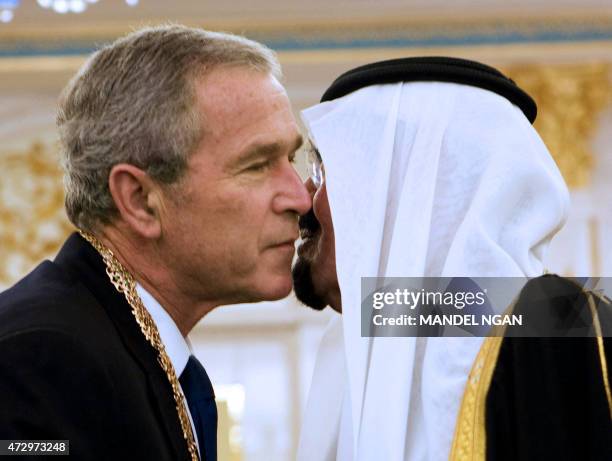 Saudi King Abdullah bin Abdul Aziz al-Saud embraces US President George W. Bush shake hands after presenting him with the King Abdul Aziz Order of...