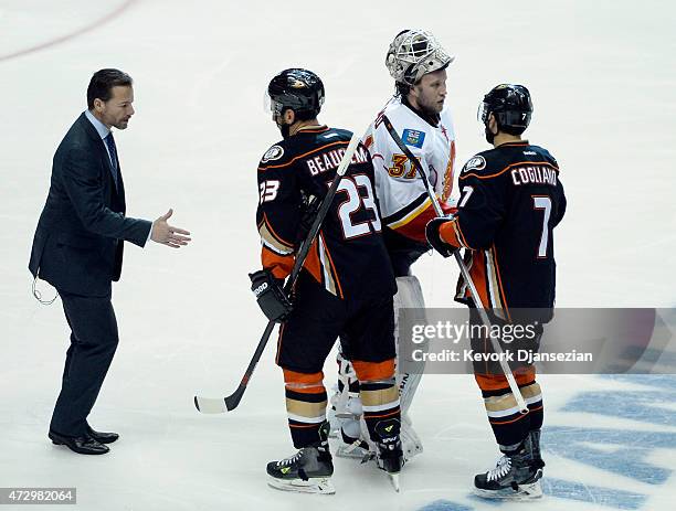Goalie Karri Ramo of the Calgary Flames shakes hands with Andrew Cogliano of the Anaheim Ducks as teammate Francois Beauchemin shakes hands with...