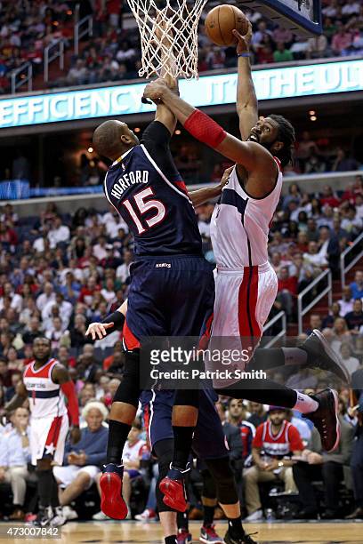 Nene of the Washington Wizards dunks over Al Horford of the Atlanta Hawks during the first half in Game Four of the Eastern Conference Semifinals of...